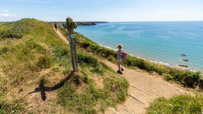 A visitor walking along the Pembrokeshire Coast Path at Marloes Sands, Pembrokeshire